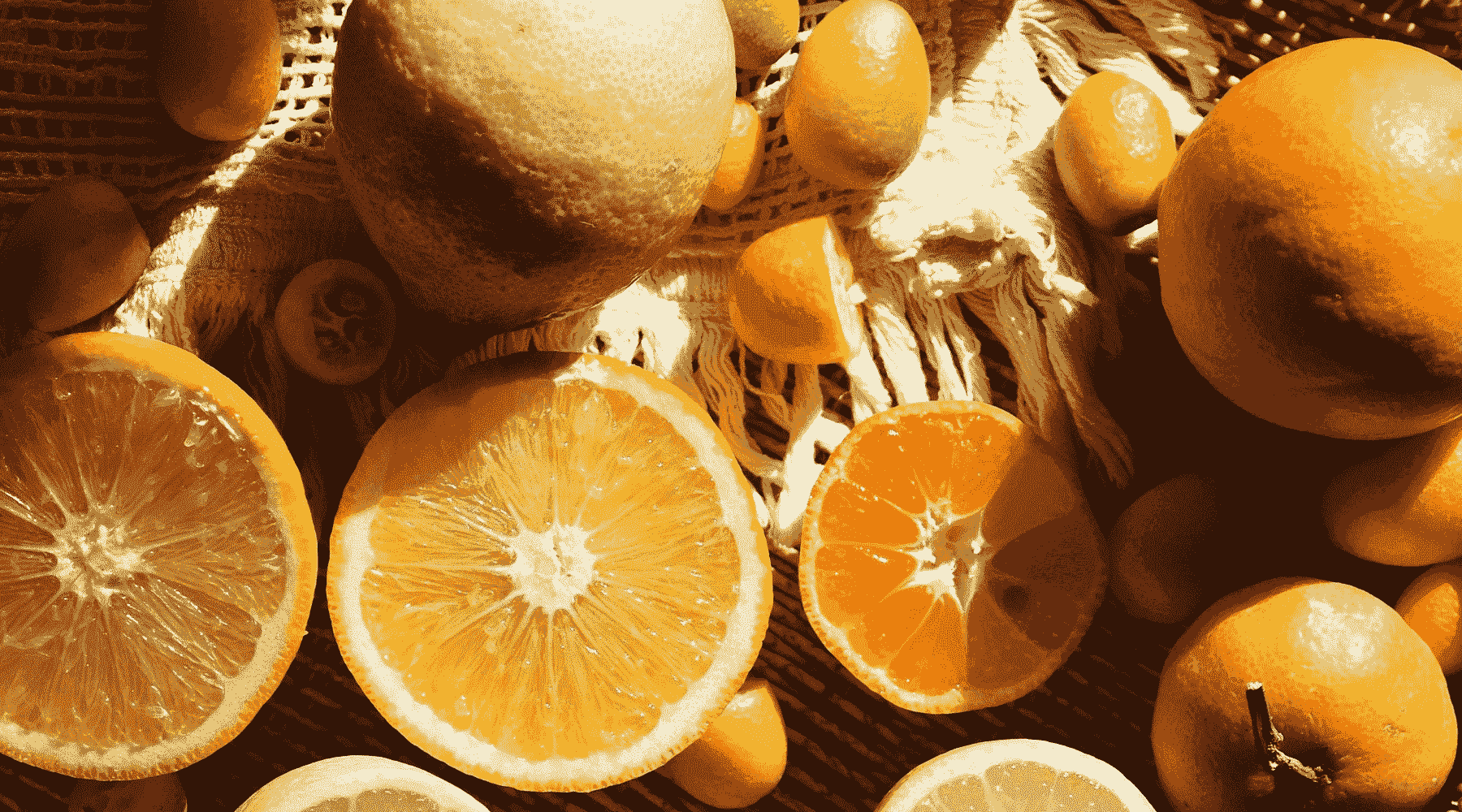 Bowl of oranges, some full, some cut in half